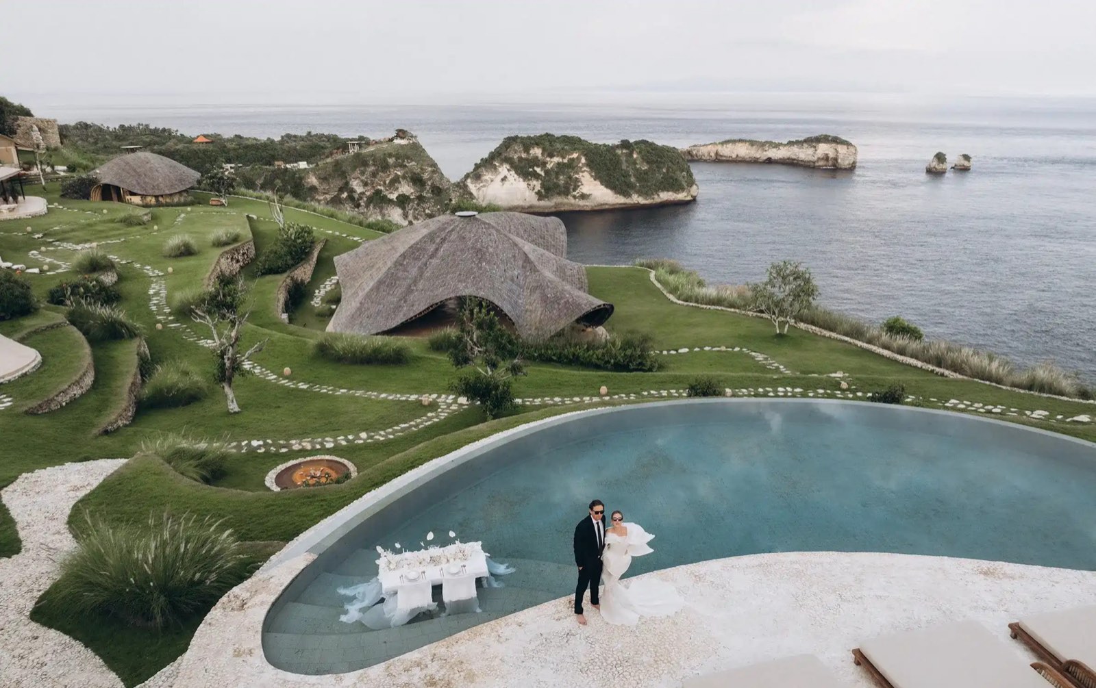 The pool on the cliff edge, the shell roofed pavilions behind it and the Nusa Penida coastline beyond